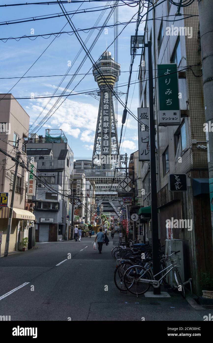 Vista della Torre Tsutenkaku a Shinsekai, Osaka, Giappone, che mostra le strade intorno alla torre, in un pomeriggio di sole. Foto Stock