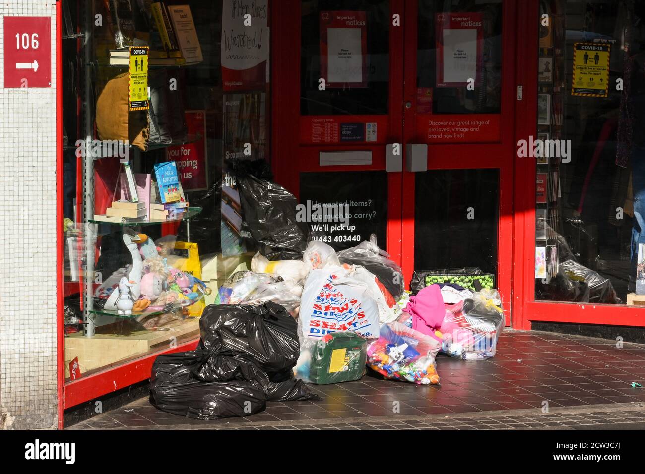Pontypridd, Galles - Settembre 2020: Borse di merci donate lasciate fuori dalla porta di un negozio di beneficenza a Pontypridd. Foto Stock