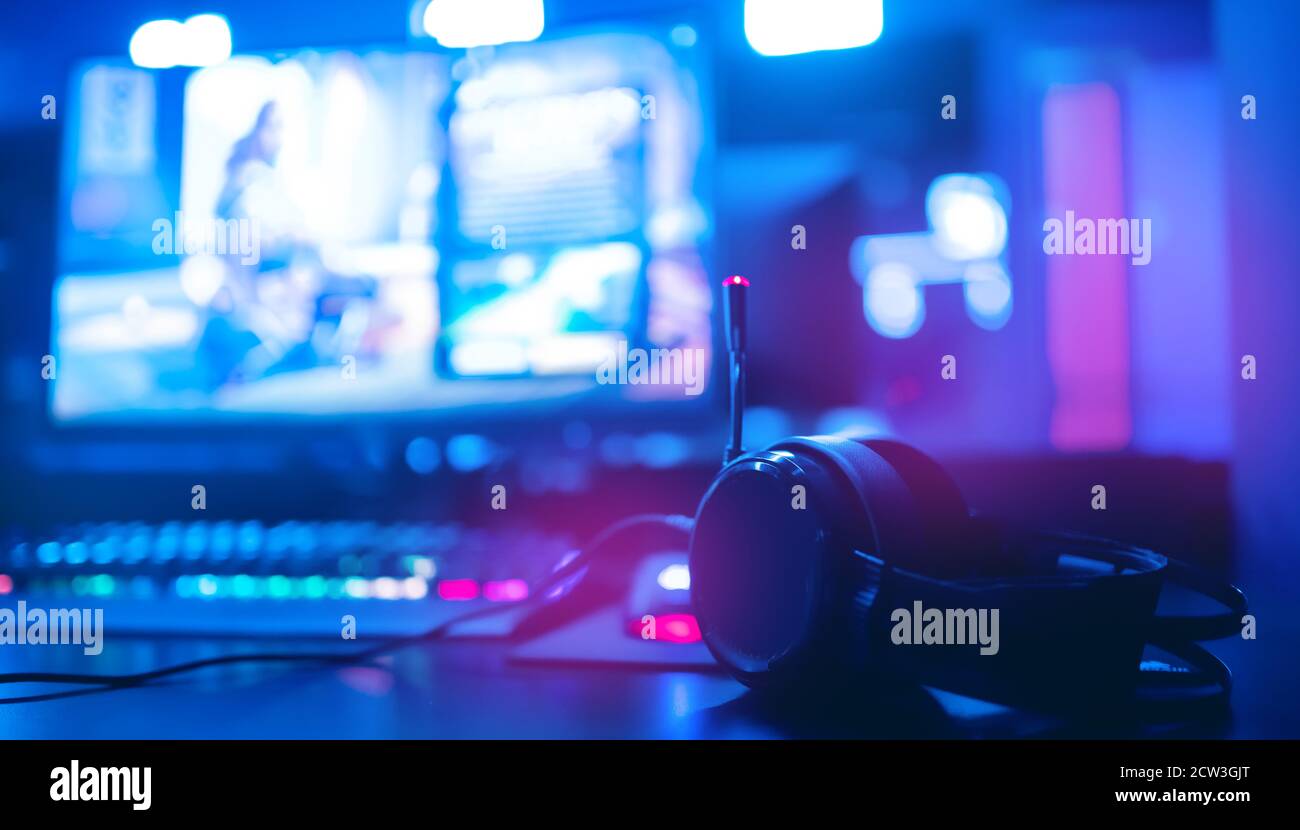 Cuffie professionali con microfono per videogiochi e sport informatici sullo sfondo del monitor di gioco Foto Stock