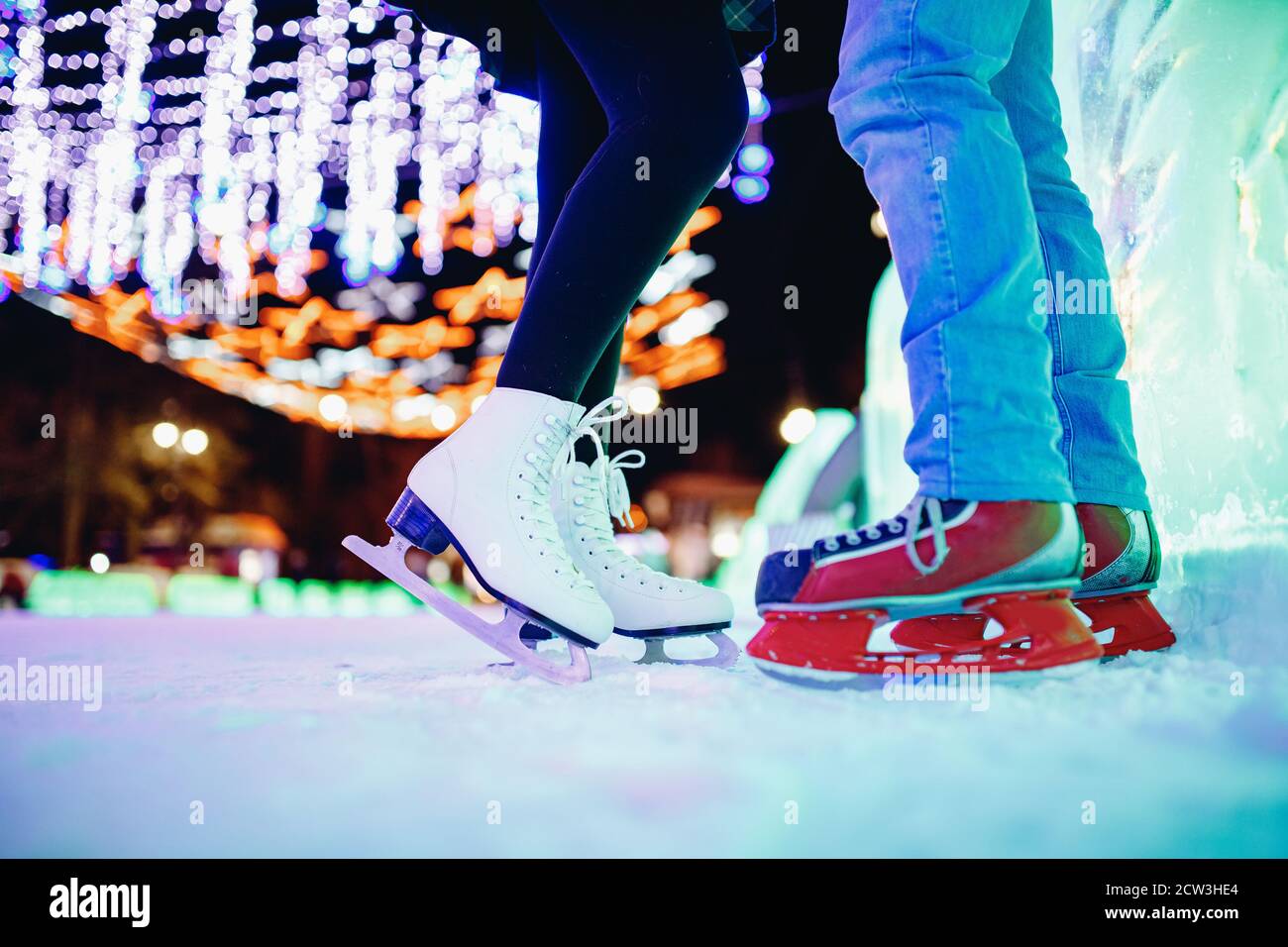 Coppia amante pattinaggio su ghiaccio divertirsi sulla neve vacanze invernali illuminazione notturna Foto Stock