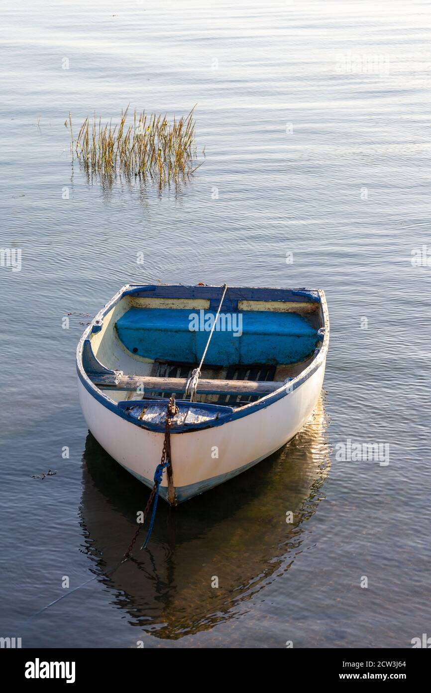 Una vecchia barca di legno ormeggiata in un porto tranquillo Foto Stock