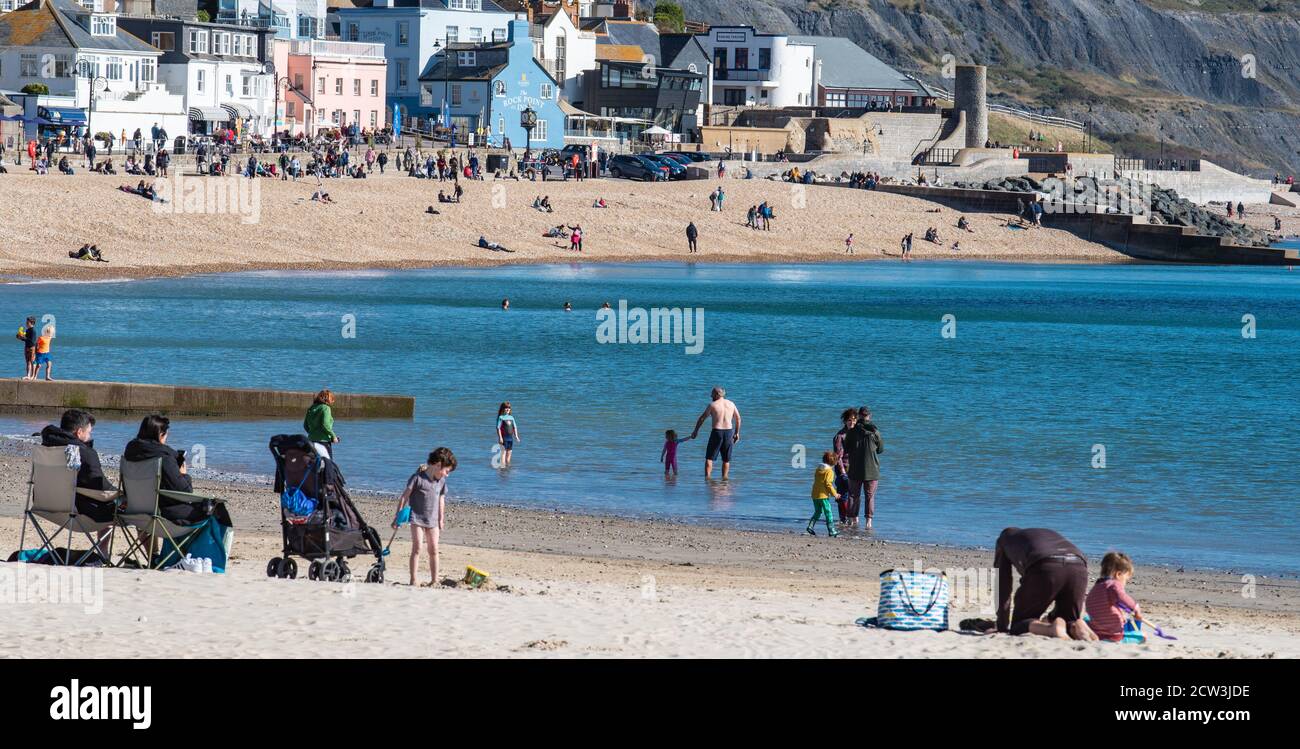 Lyme Regis, Dorset, Regno Unito. 27 Settembre 2020. Regno Unito Meteo: Una giornata luminosa e soleggiata con un vento freddo a Lyme Regis. La gente si avvolge caldo per godere di una passeggiata a rischio lungo il lungomare di Lyme Regis. Credit: Celia McMahon/Alamy Live News Foto Stock