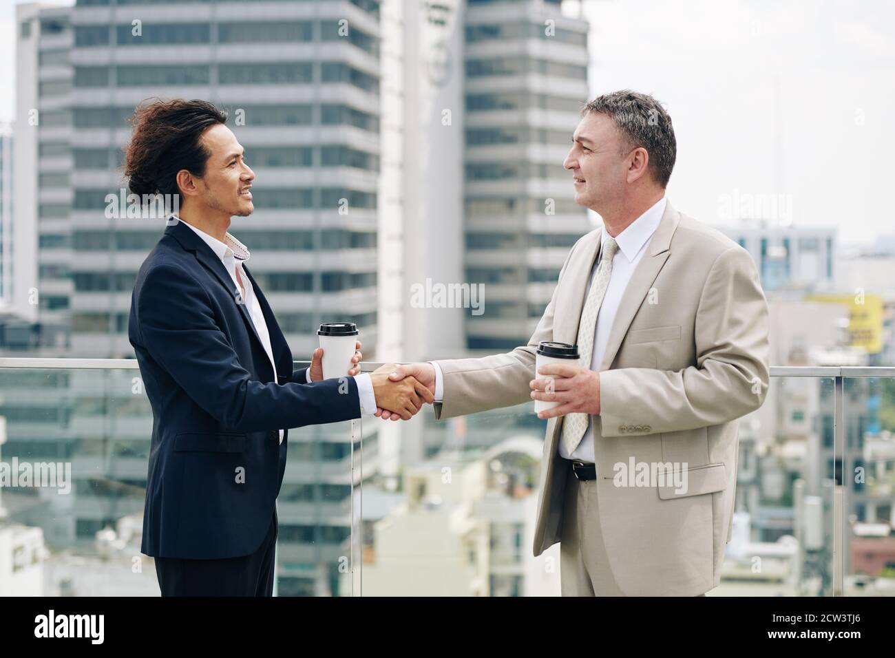 Imprenditori sorridenti che scuotono le mani Foto Stock