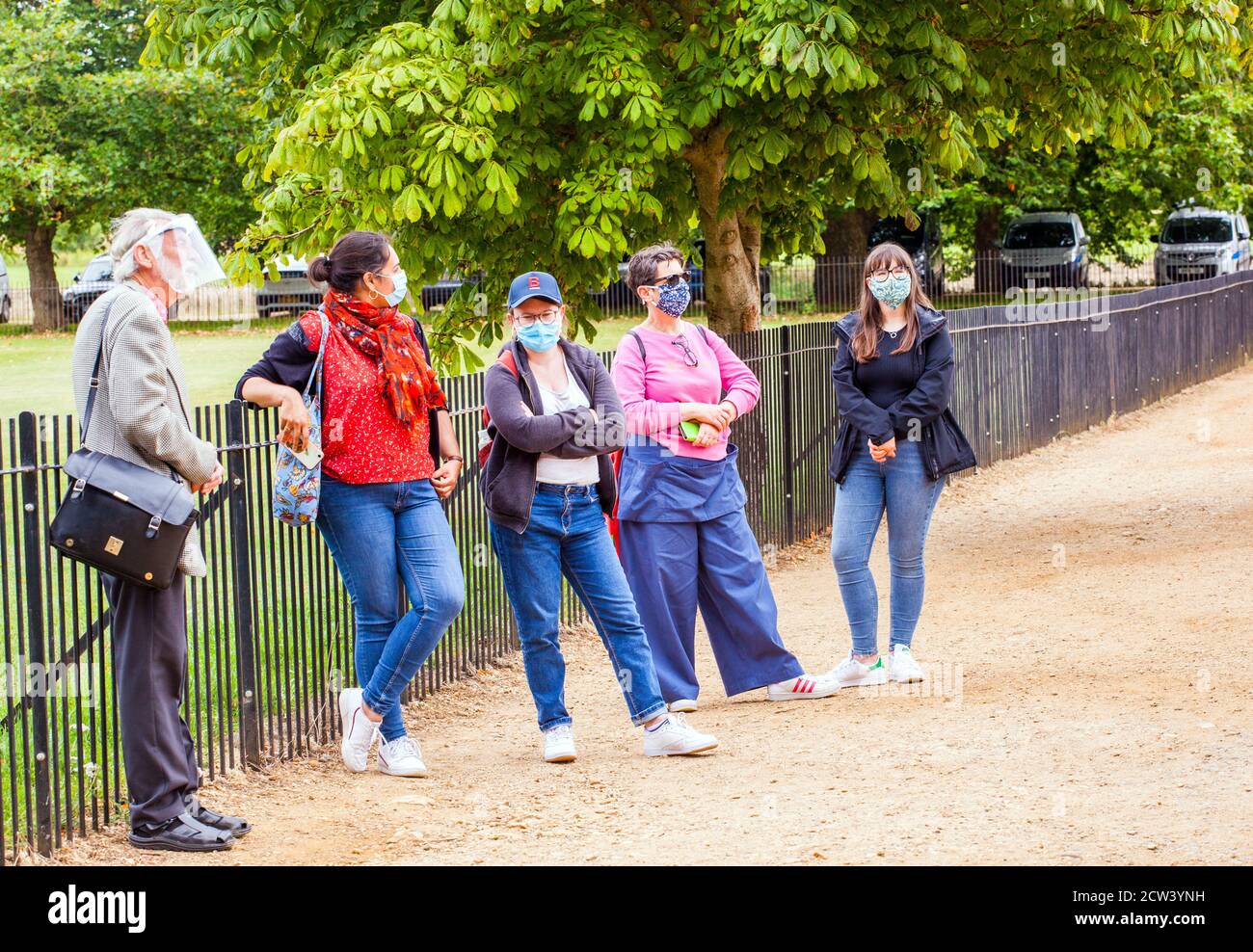 Turisti che indossano maschere per il viso / copertura viso su una passeggiata guidata Tour della città dell'Oxfordshire di Oxford durante il covid 19 pandemia Foto Stock