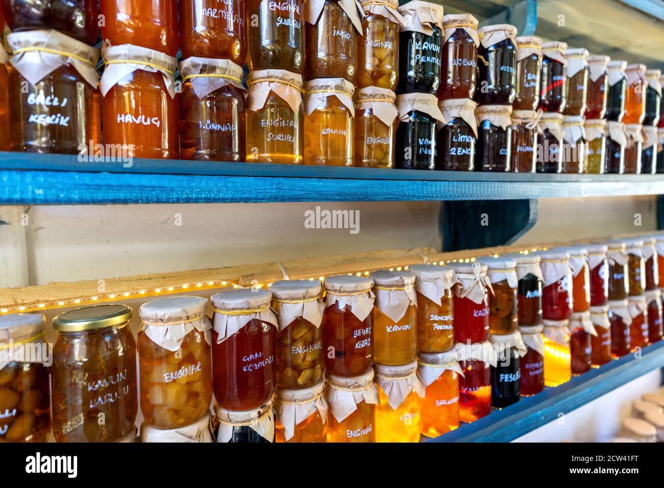 Marmellate colorate in vasetti di vetro. Traduzione: "Nomi di frutta diversi". Foto Stock