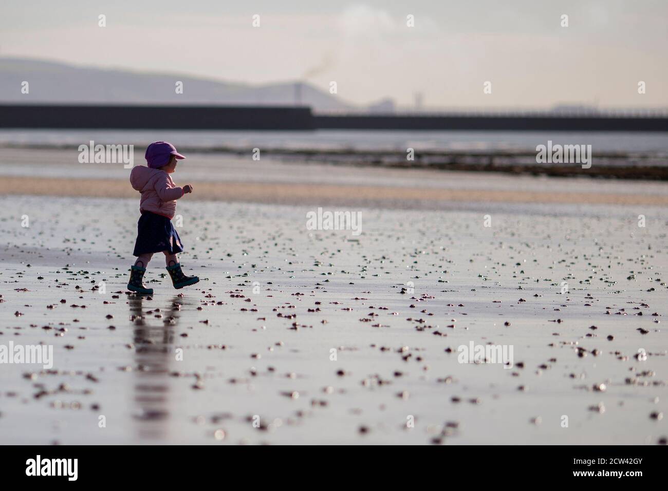 Swansea, Galles, Regno Unito. 27 Settembre 2020. Un toddler da Cardiff esplora la spiaggia di Swansea prima di nuovi blocchi locali dal 18.00 per rallentare la diffusione del coronavirus a Swansea e Cardiff. I blocchi locali sono anche in luogo a Llanelli, Caerphilly, Rhondda Cynon Taf, Merthyr, Bloenau Gwent e Bridgend. Credit: Mark Hawkins/Alamy Live News Foto Stock