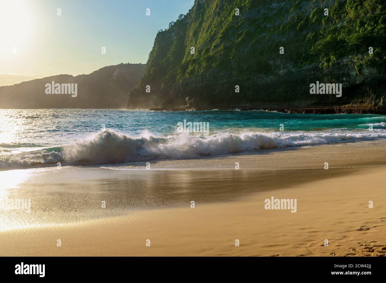 Ocean Wave e Kelingking Beach al tramonto sull'isola di Nusa Penida, Bali in Indonesia. Foto Stock