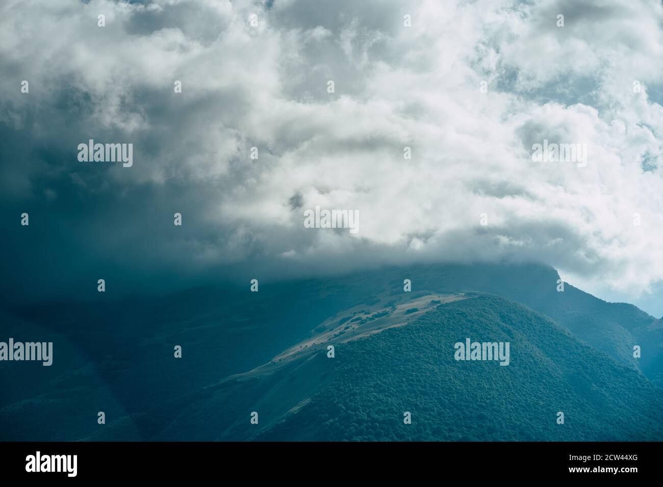 Cime di montagna contro cielo nuvoloso. Picchi di magnifiche rocce situate contro il cielo nuvoloso e luminoso Foto Stock