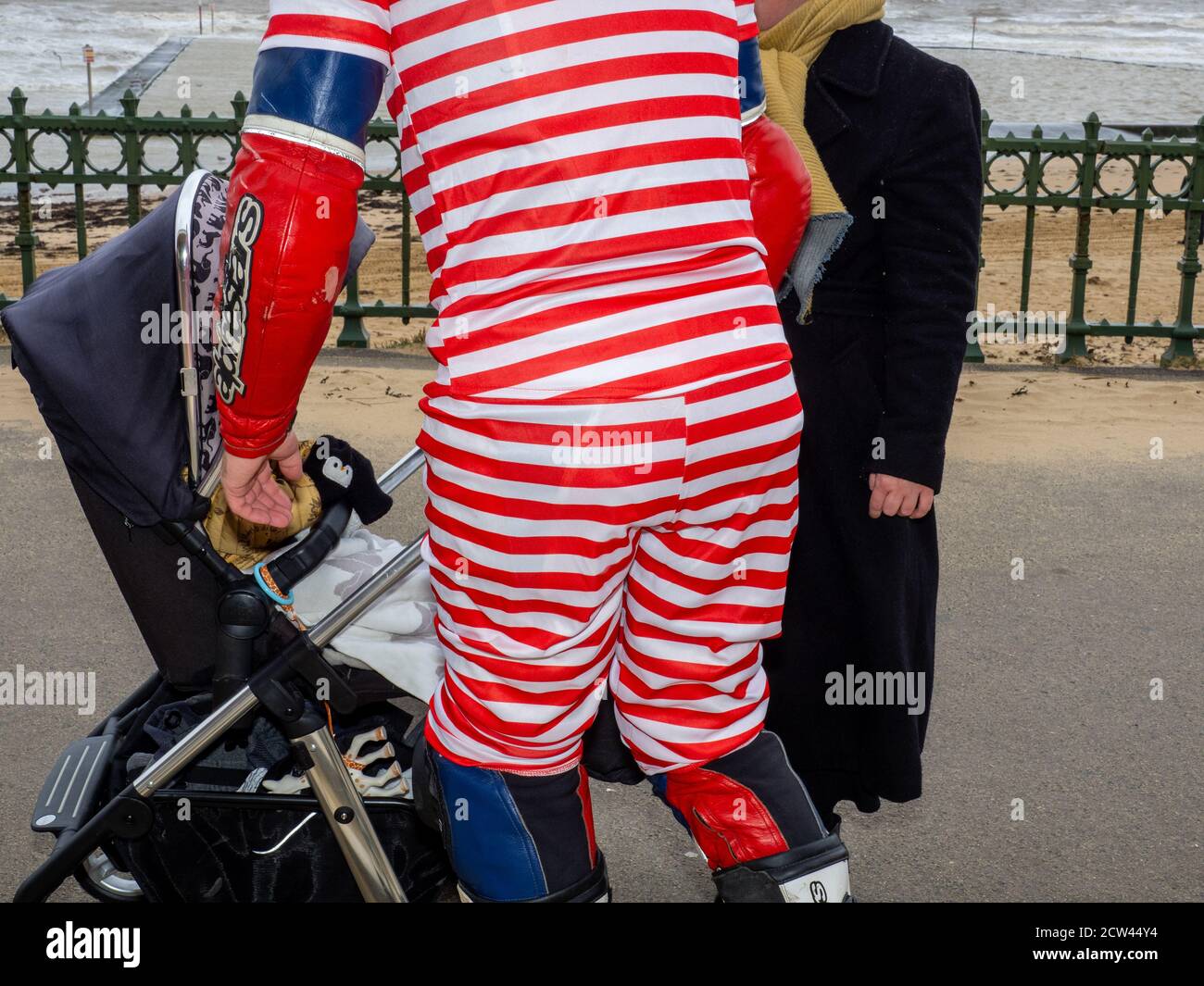 Un uomo che indossa un auit a strisce rosse e bianche sulla passeggiata di Margate. Foto Stock