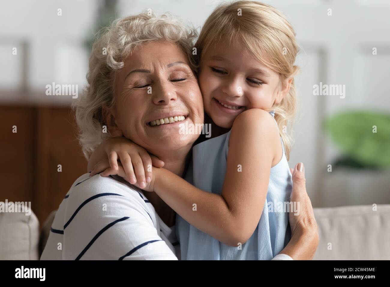 Ritratto di nonna anziana coccolante amato nipote occhi di chiusura Foto Stock