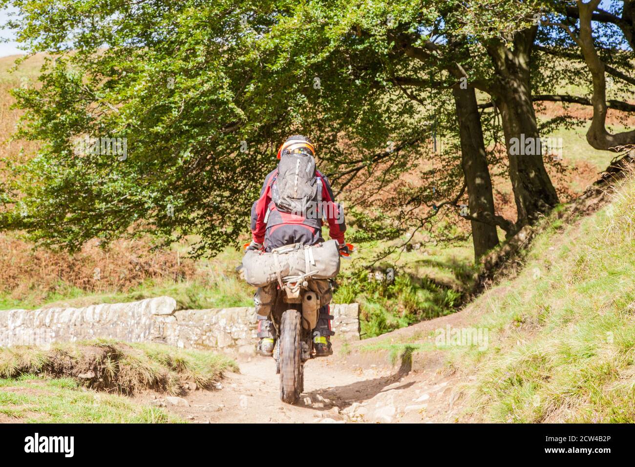 Motociclisti fuoristrada che utilizzano una pista verde che attraversa il Ponte di pietra ai tre shires testa nel picco Distretto parco nazionale Inghilterra Regno Unito Foto Stock