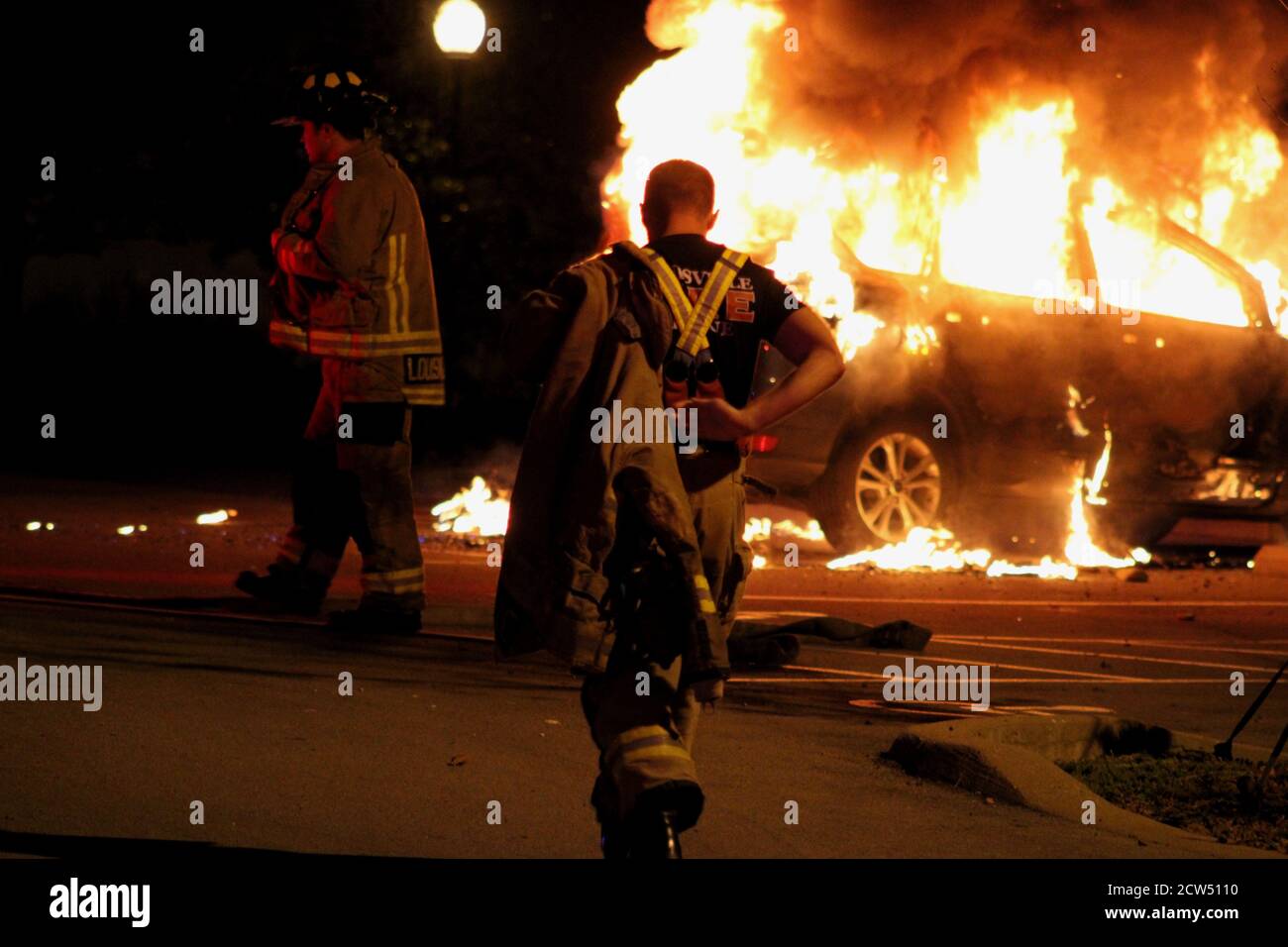 Louisville, Kentucky, Stati Uniti. 26 Settembre 2020. I vigili del fuoco hanno messo fuori un fuoco di automobile dopo un piccolo gruppo di gente a Louisville, KY ha rotto via dal gruppo principale di protesta che stava cercando il rifugio alla prima chiesa uniseralista unita alla fine di sabato notte. Gli altri rally-goers della brutalità anti-polizia sono stati sconcertati quando uno di loro ha messo fuori i firecrackers, che hanno fatto la maggior parte della gente rifiutarsi di marciare con loro o di lasciarli indietro all'interno della chiesa. Alcuni hanno fatto un'aragosta dopo il confronto in un'auto parcheggiata. Ha preso fuoco ed ha scoppiato nelle fiamme in un parcheggio dell'università di Spaulding. (Credito Foto Stock