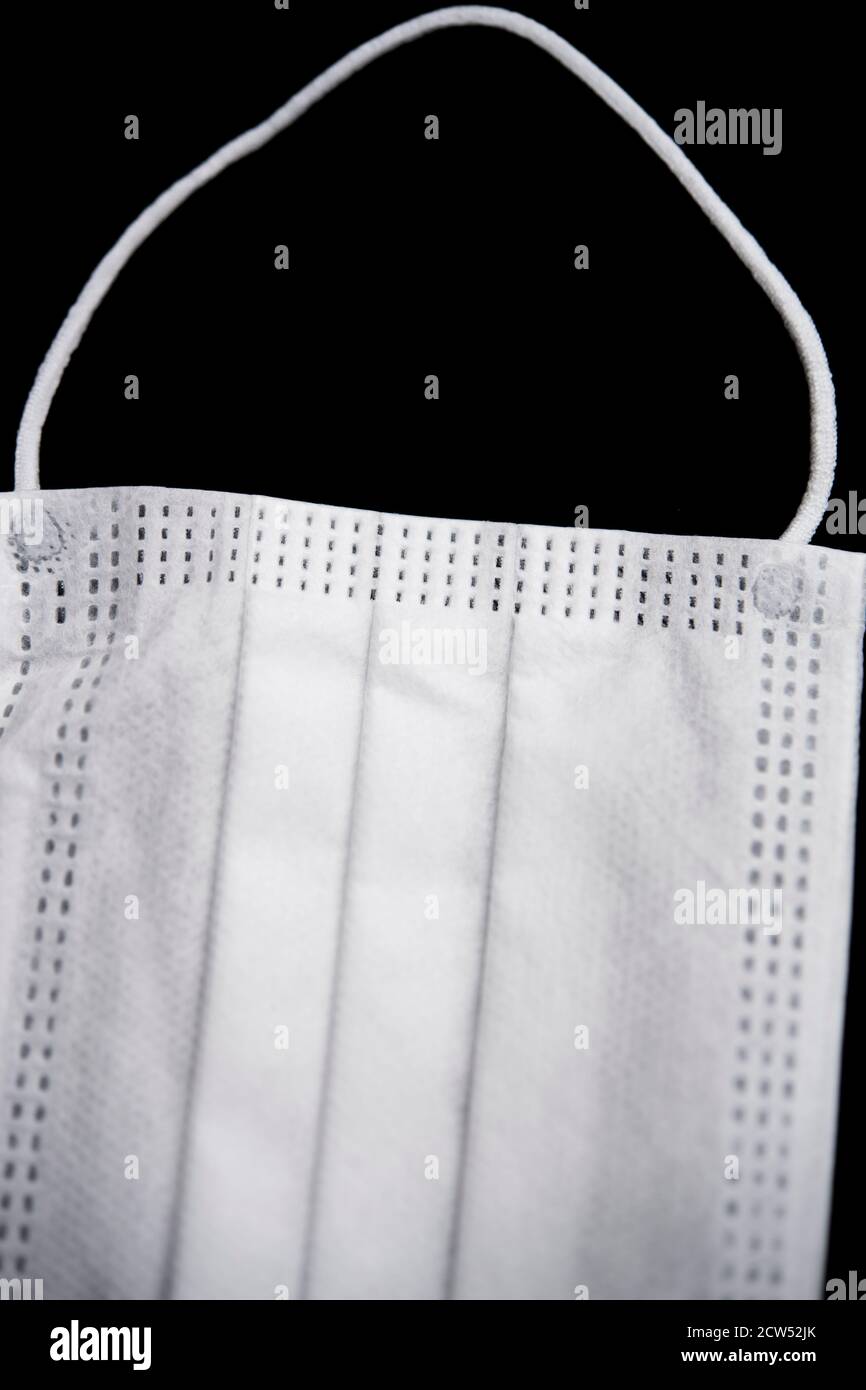 Maschera protettiva bianca isolata su sfondo nero Foto Stock