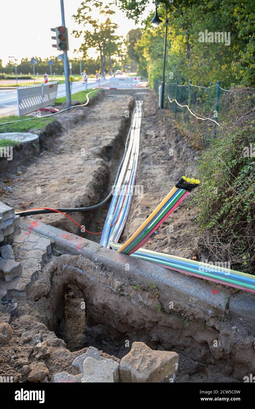 cantiere per l'installazione di cavi in fibra ottica sotto terra per internet veloce in una strada di un villaggio tedesco, fuoco selezionato, profondità stretta o Foto Stock