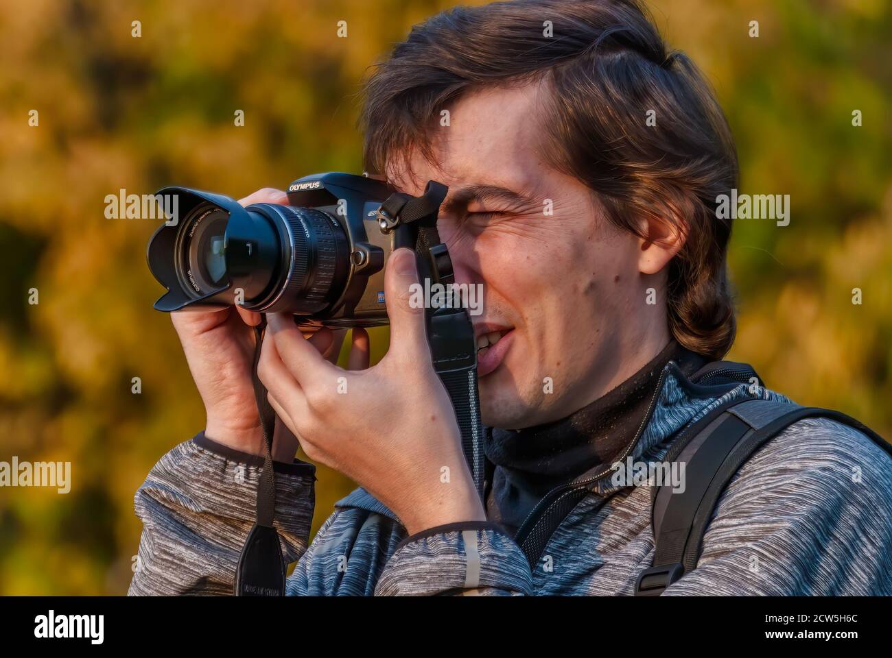 Il fotografo maschile sta scattando una foto con una fotocamera digitale Foto Stock