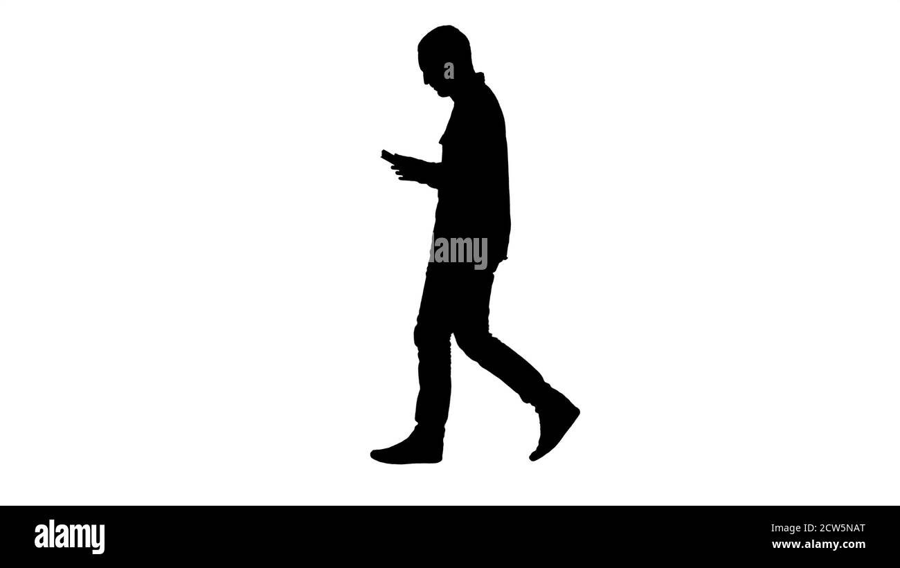 Silhouette sicura uomo serio che cammina e lavora in un tablet. Foto Stock