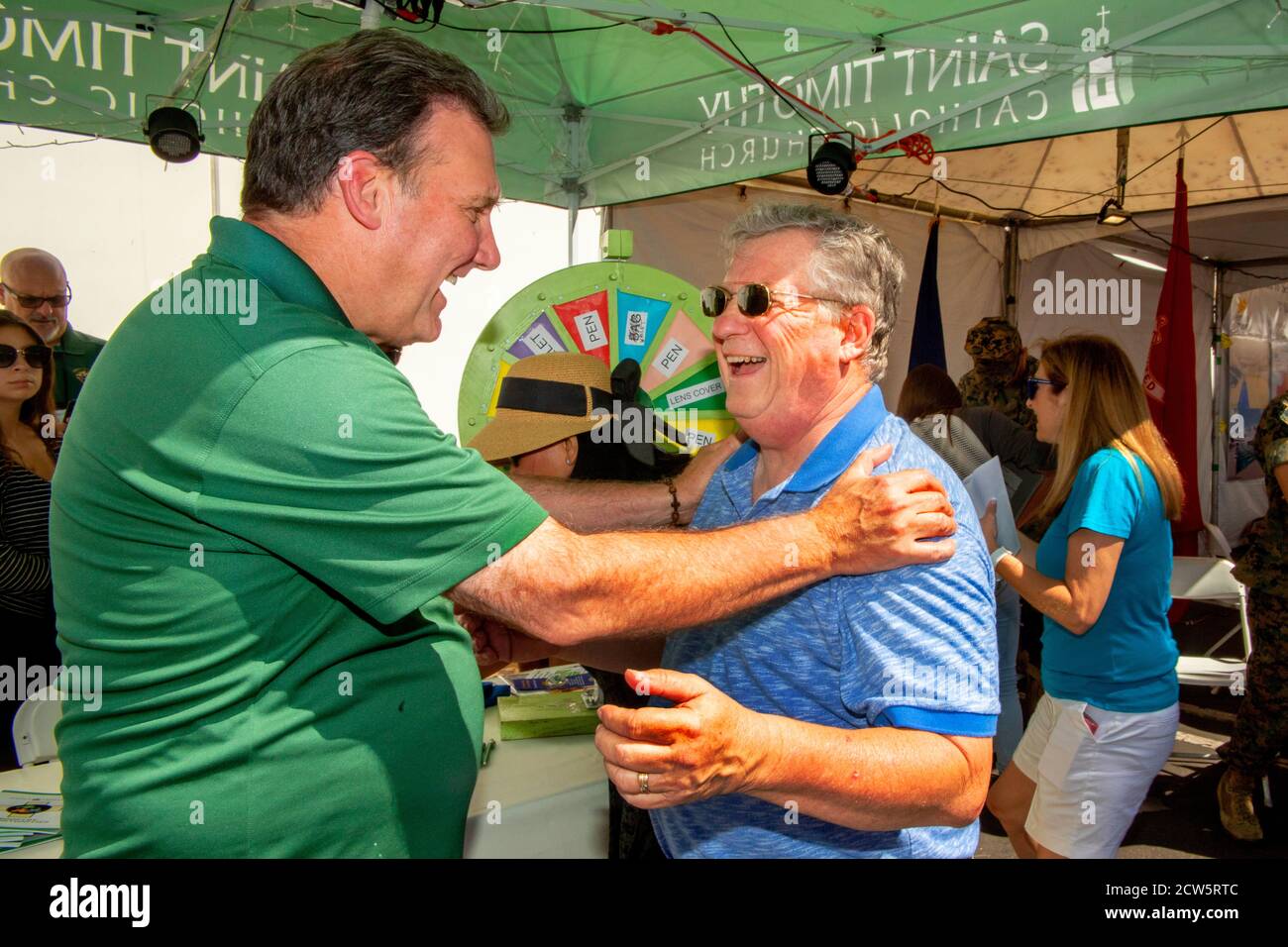Un diacono cattolico socializza con i parrocchiani in una mostra di fuorilegge di una fiera di strada a Laguna Niguel, CA. Foto Stock