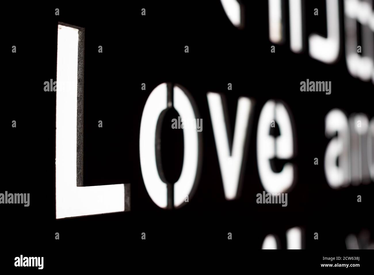 Parola d'amore in lettera illuminata su uno sfondo nero primo piano visualizza Foto Stock