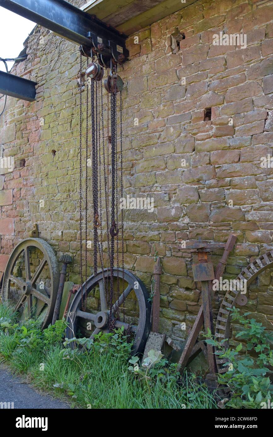 Un paio di grandi paranchi a catena su una grande trave in acciaio appesa tra 2 fienili in una fattoria a Cumbria, Regno Unito Foto Stock