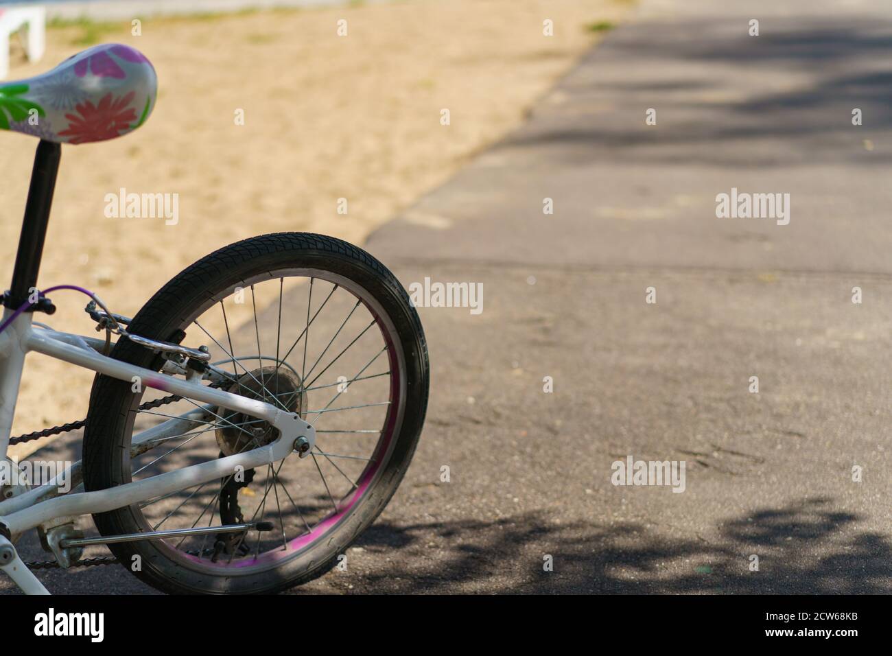 Fotografia della ruota posteriore di una bicicletta per bambini parcheggiata. Tema del tempo libero. Concetto di stile di vita sano. Foto Stock