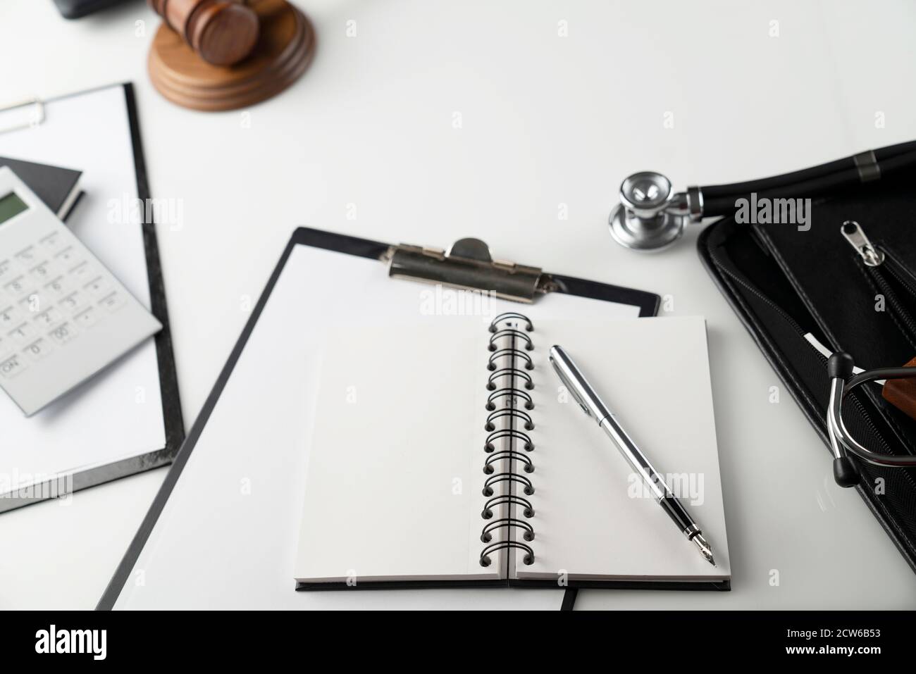 Concetto di legge medica. Gavel, stetoscopio e taccuino sul tavolo. Foto Stock