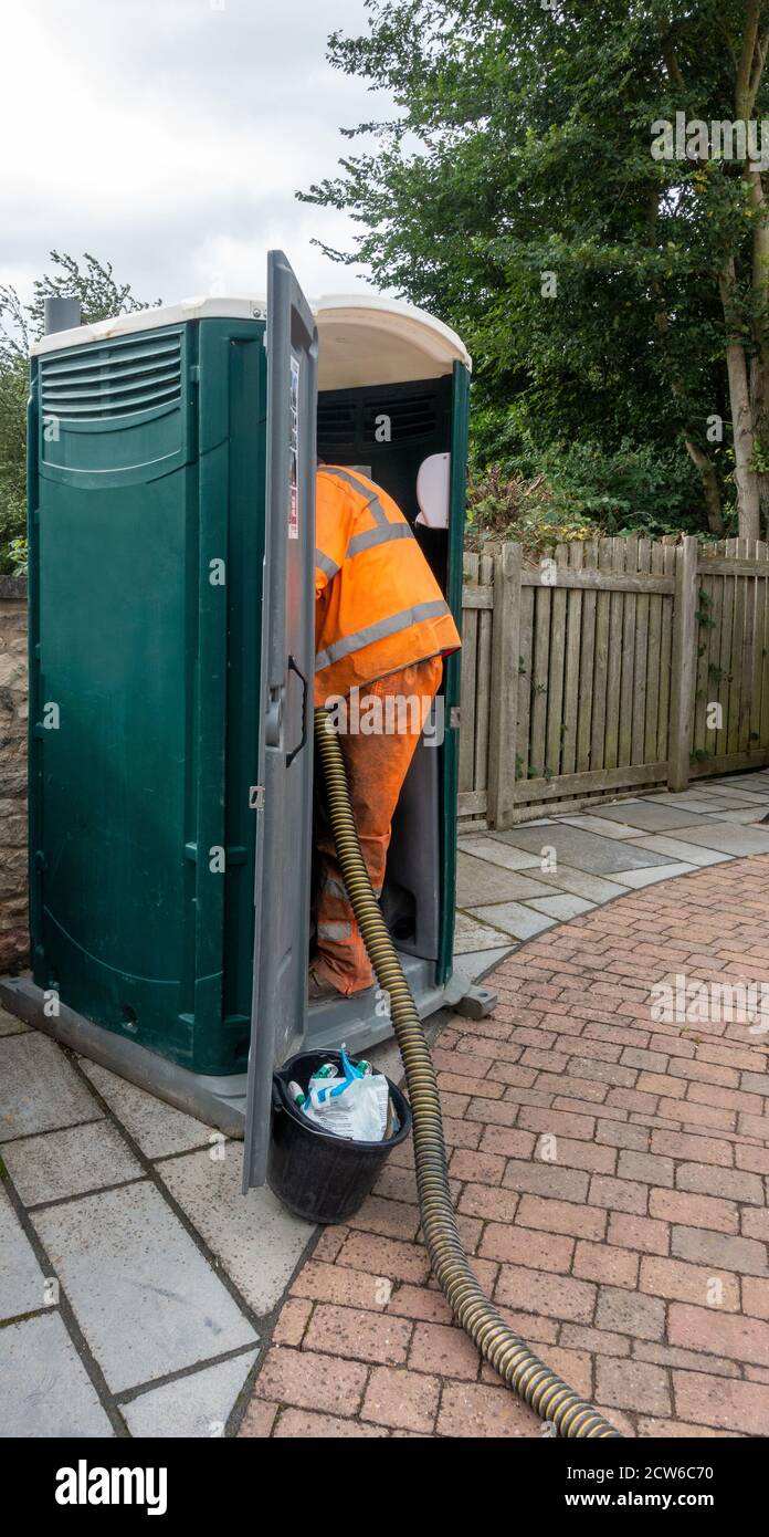 Progettare la pulizia utilizzando il tubo di aspirazione della fogna in corrispondenza del wc temporaneo Foto Stock