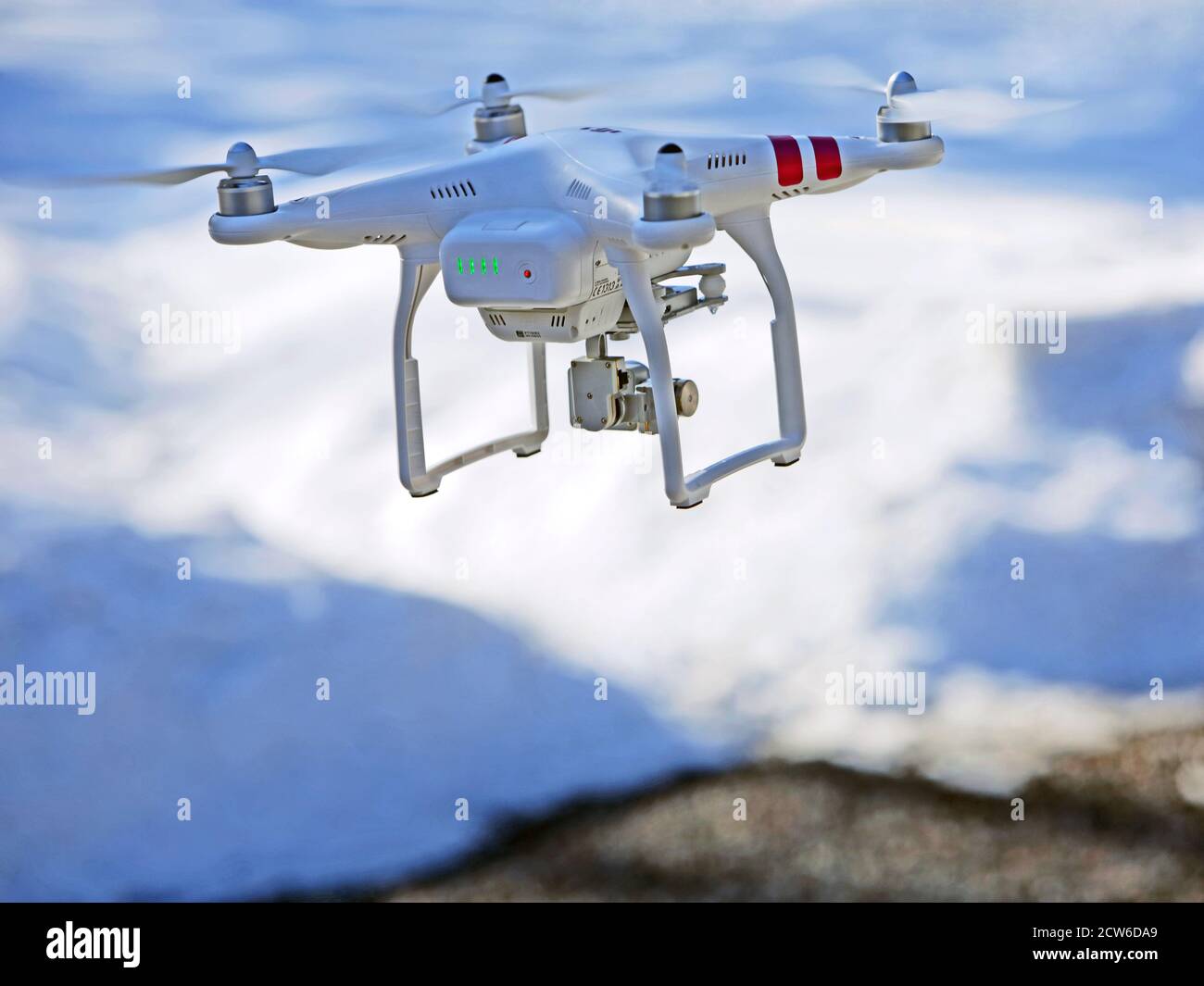 Quad-copter Drone con videocamera collegata in missione di ricerca e salvataggio, volare basso su terreno nevoso. Foto Stock