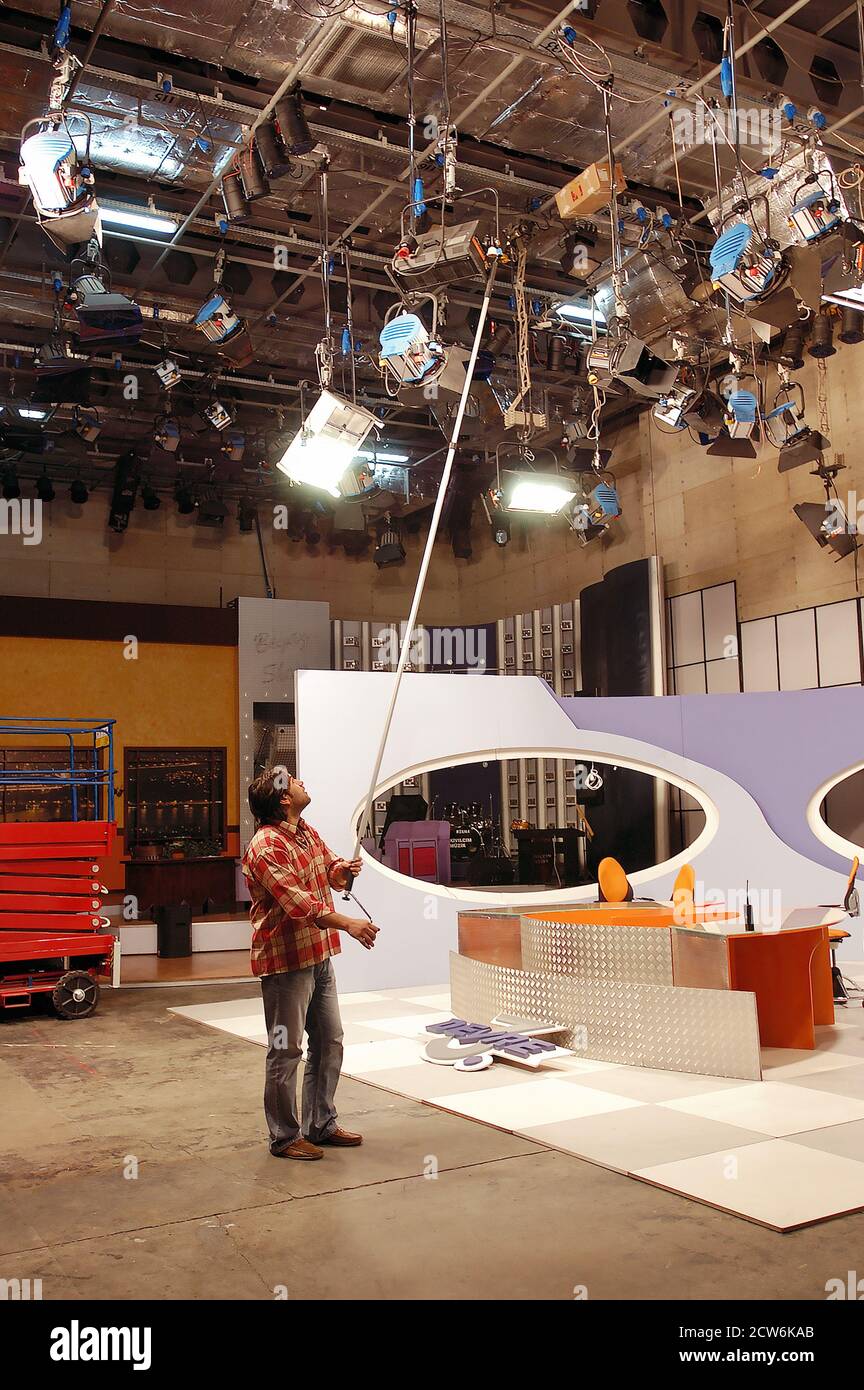 Un lavoro di una stazione TV sta fissando il si accende prima della trasmissione Foto Stock