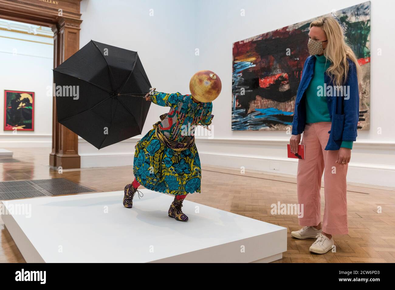 Londra, Regno Unito. 28 settembre 2020. Un membro dello staff si pone con 'Air Kid (ragazza)' di Yinka Shonimbare RA. Anteprima della Mostra estiva alla Royal Academy of Arts di Piccadilly che, grazie al blocco Covid-19, si svolge per la prima volta in autunno. Oltre 1000 opere su una gamma di media di accademici reali, artisti affermati ed emergenti, sono presenti nella mostra che va dal 6 ottobre 2020 al 3 gennaio 2021. Credit: Stephen Chung / Alamy Live News Foto Stock