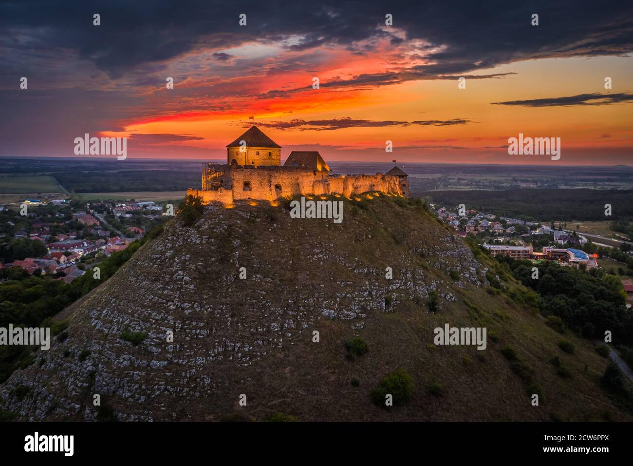 Sumeg, Ungheria - Vista aerea del famoso High Castle illuminato di Sumeg nella contea di Veszprem al tramonto con nuvole colorate e colori drammatici di s. Foto Stock