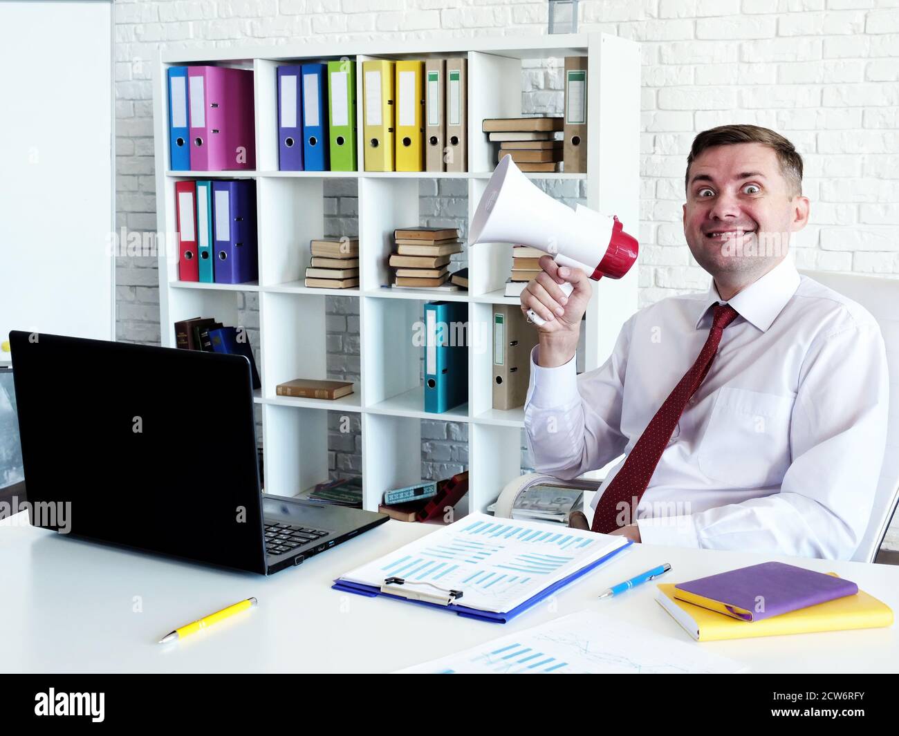 Concetto di leadership di pensiero. Problemi con boss difettoso. Un uomo con un altoparlante in ufficio. Foto Stock