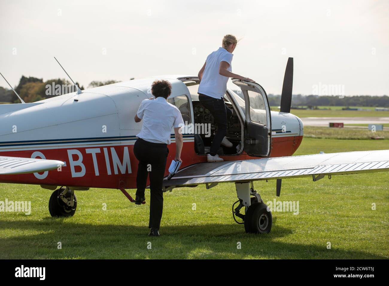 Gloucestershire, Inghilterra, Regno Unito. 2020. Una studentessa sta per prendere una lezione di volo con il suo istruttore da un campo d'aviazione inglese. Pilota e istruttore per studenti Foto Stock