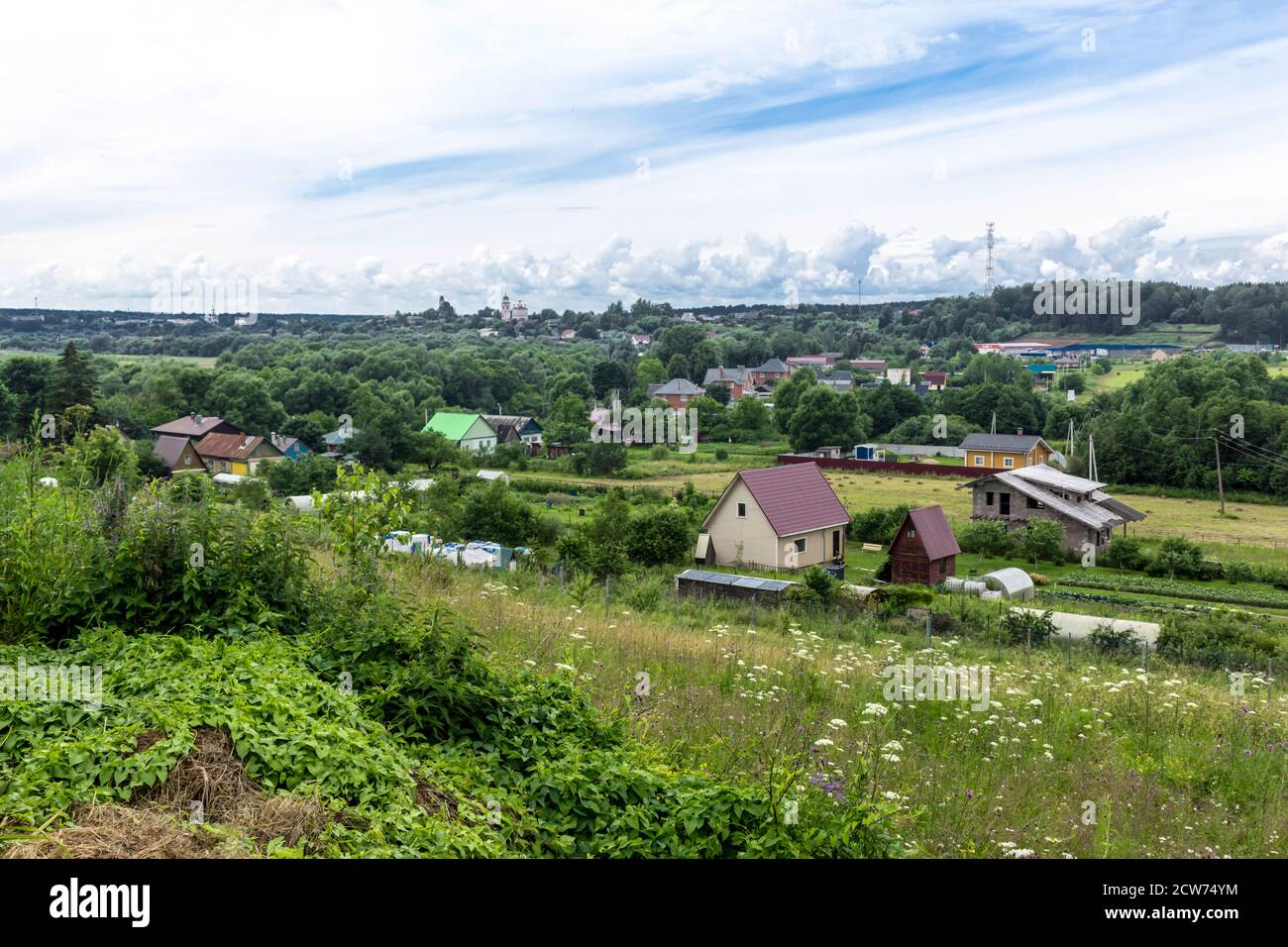 Metà estate. Cottage, alberi verdi e un tempio all'orizzonte. Vista dalla collina. Città Provinciale di Borovsk in Russia. Foto Stock