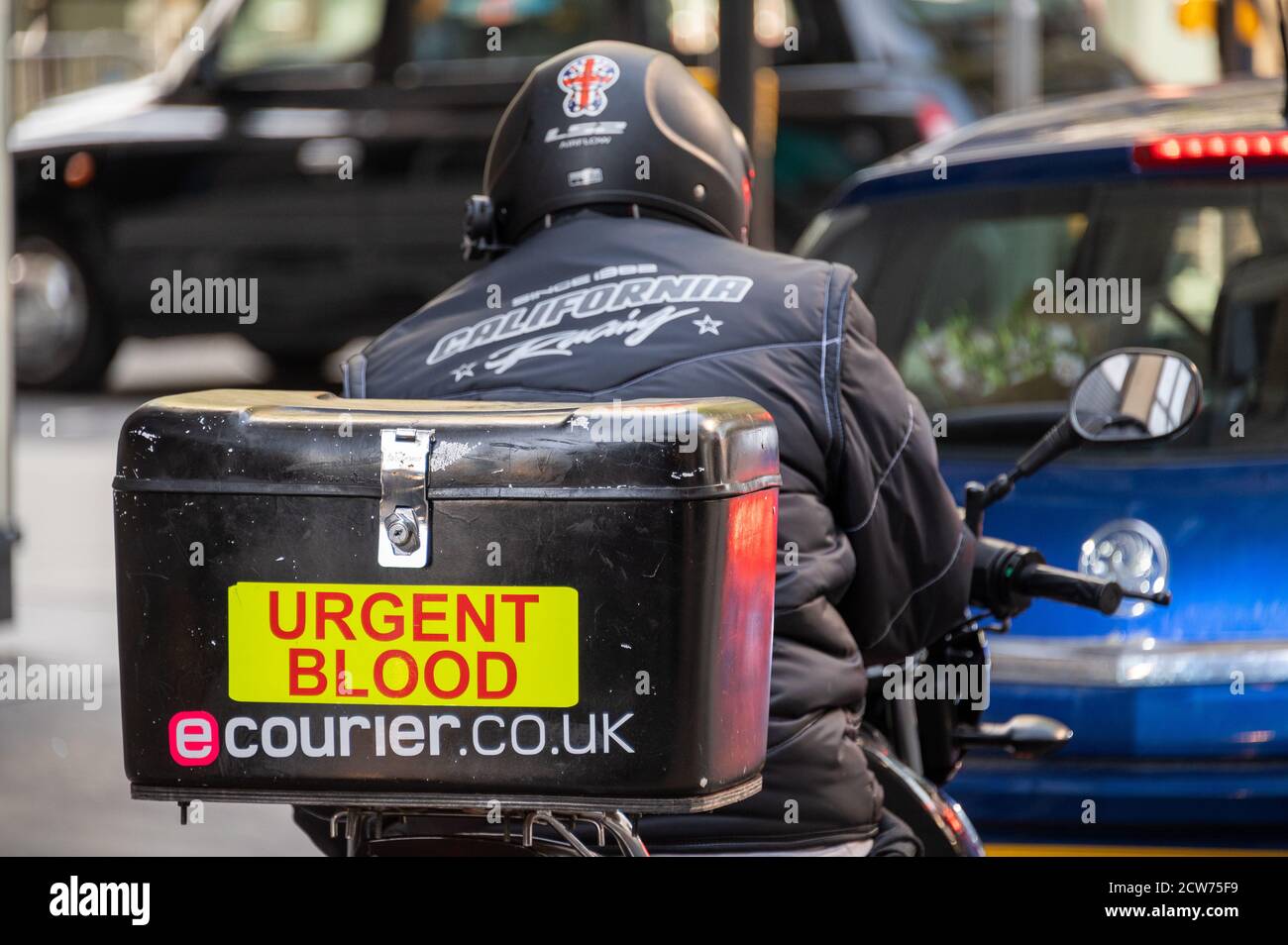 LONDRA - 12 SETTEMBRE 2020: Corriere medico del motociclo nel traffico con sangue urgente scritto sulla sua scatola del carico Foto Stock