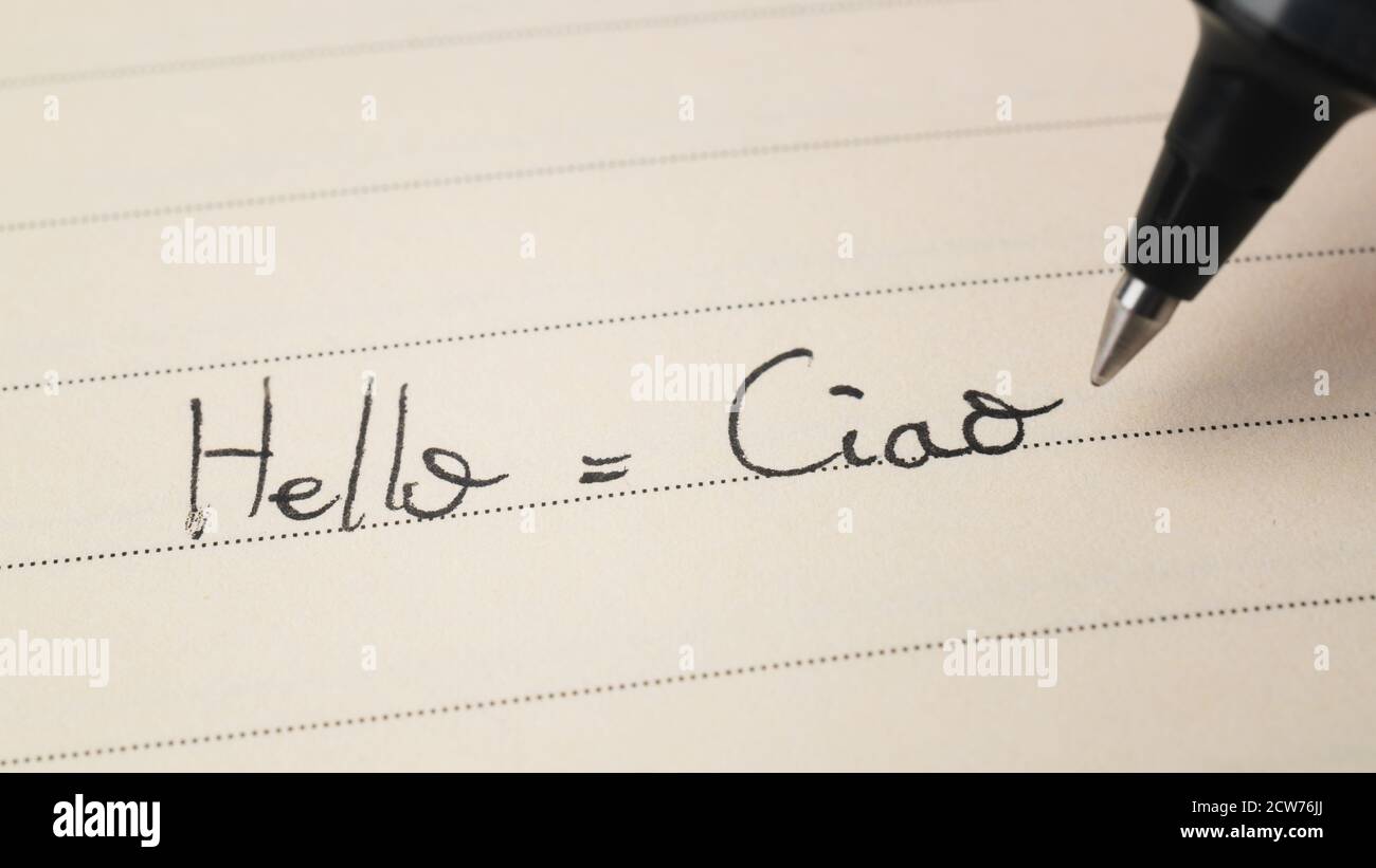 Principiante studente di lingua italiana che scrive Ciao parola Ciao per i compiti su uno scatto macro del notebook Foto Stock