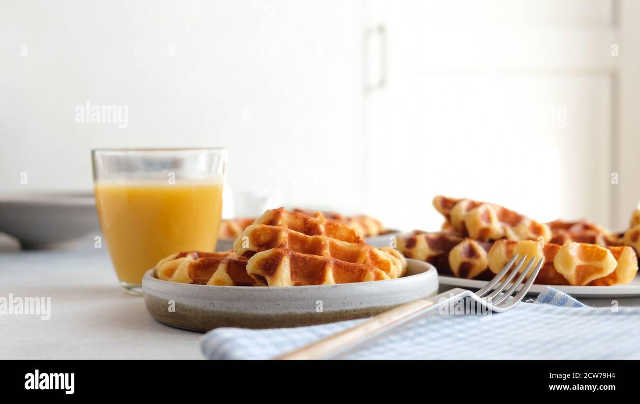 Colazione con waffle belgi e succo d'arancia su un tavolo Foto Stock