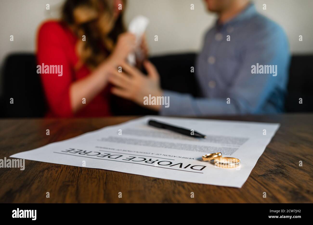 Documento di decreto di divorzio. L'uomo calma giù una donna sullo sfondo. Foto Stock