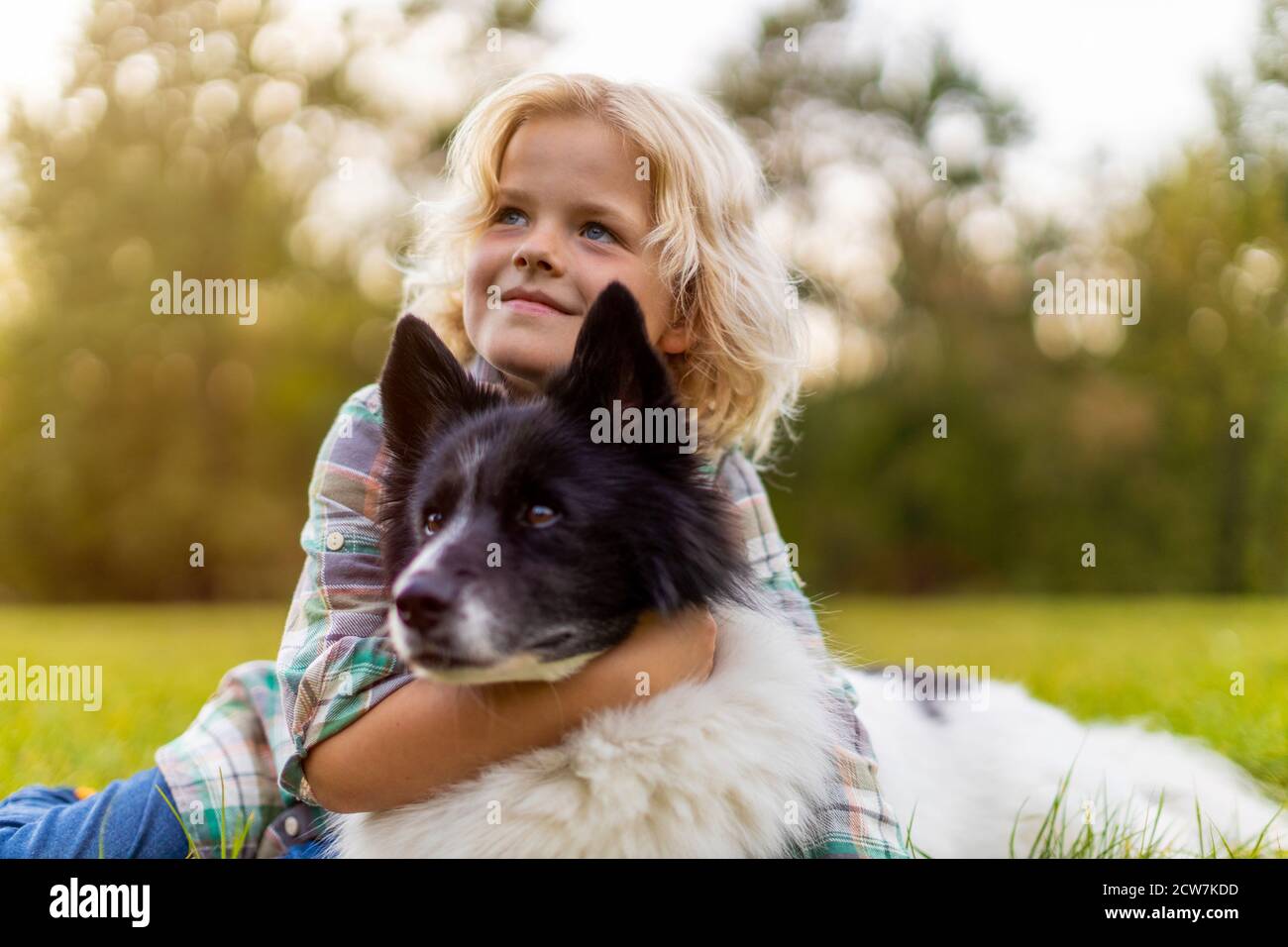 Piccolo ragazzo che gioca con il suo cane all'aperto nel parco Foto Stock
