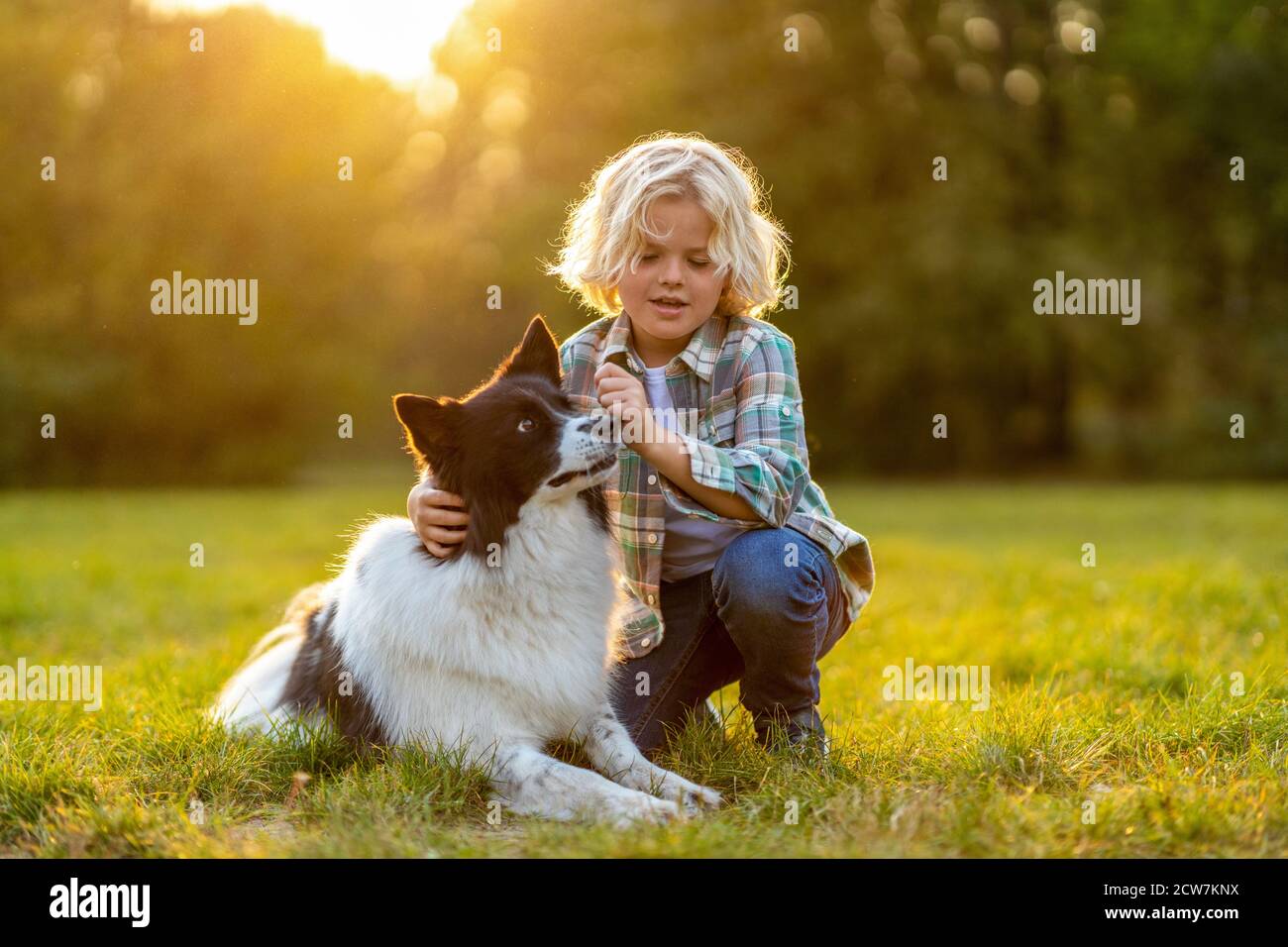 Piccolo ragazzo che gioca con il suo cane all'aperto nel parco Foto Stock