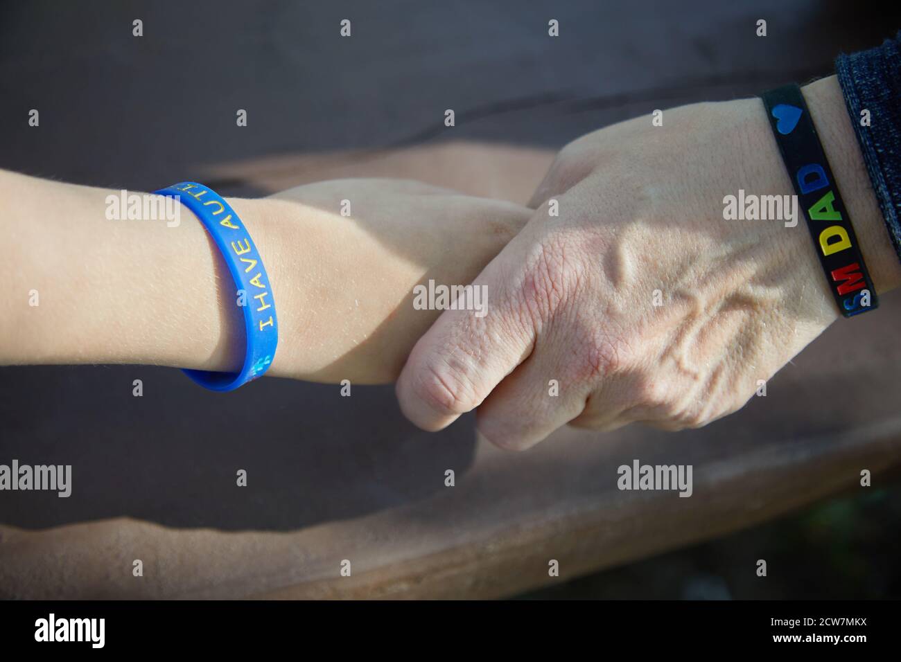 Consapevolezza autismo. Il padre tiene la mano il suo bambino autistico. Foto Stock