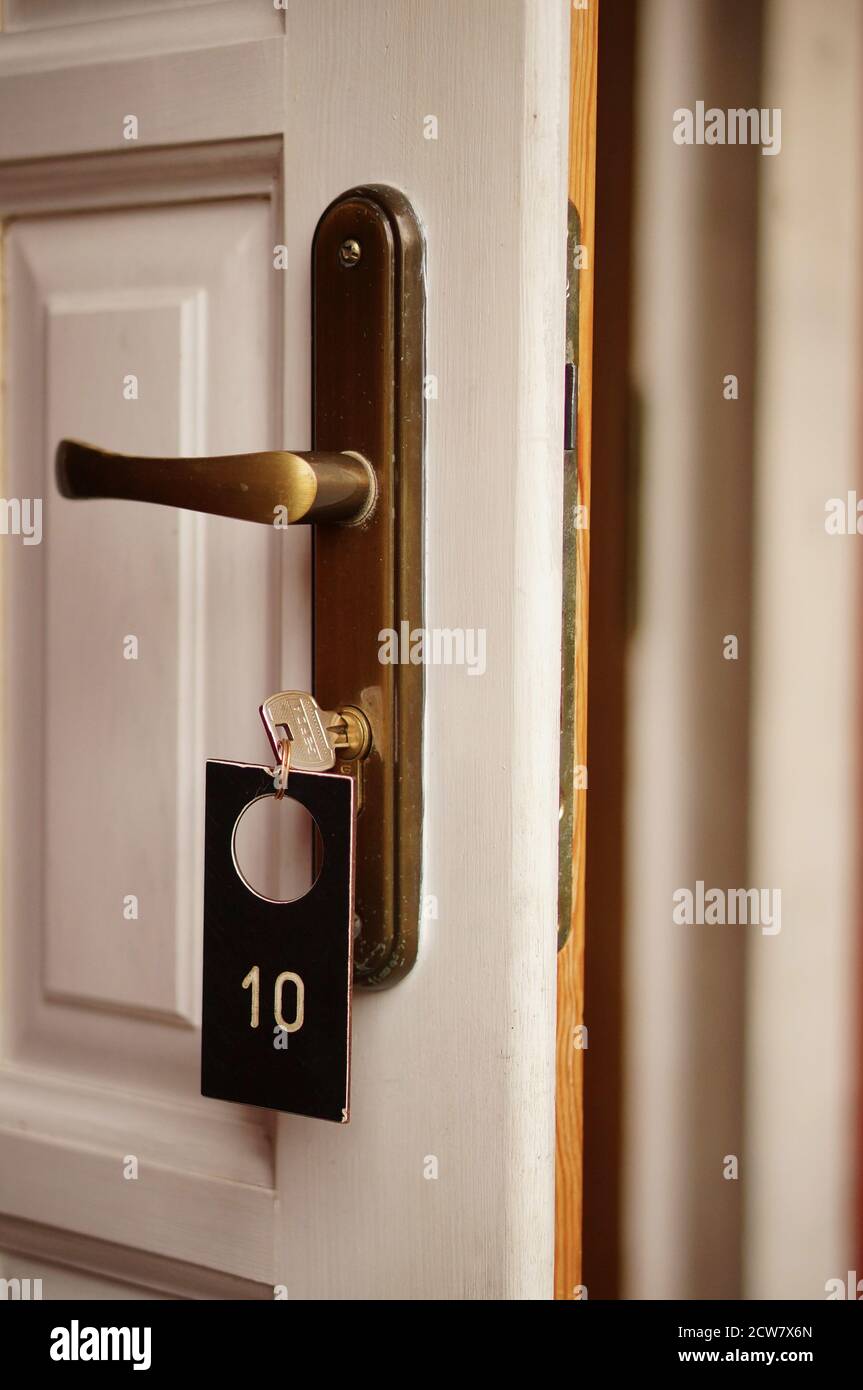 TLEN, POLONIA - 17 agosto 2020: Primo piano di una porta aperta in legno bianco con maniglia dorata e lotto di chiavi numero 10. Foto Stock