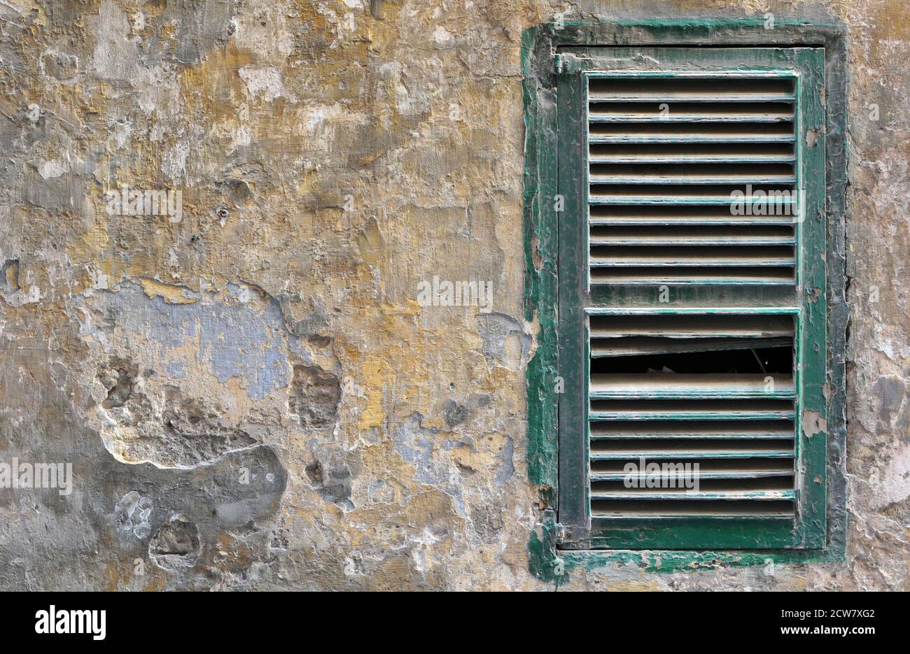 Dettaglio che mostra una serranda verde spezzata sulla parete di un vecchio edificio stagionato a la Valletta, Malta. Foto Stock