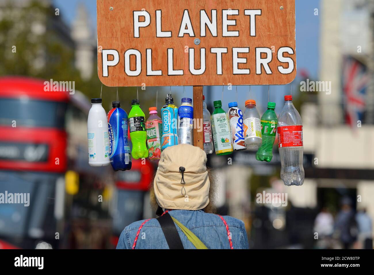 Londra, Inghilterra, Regno Unito. Protetore ambientale regolare in Piazza del Parlamento con il banner 'Plastic Producers Planet Polluters' Foto Stock