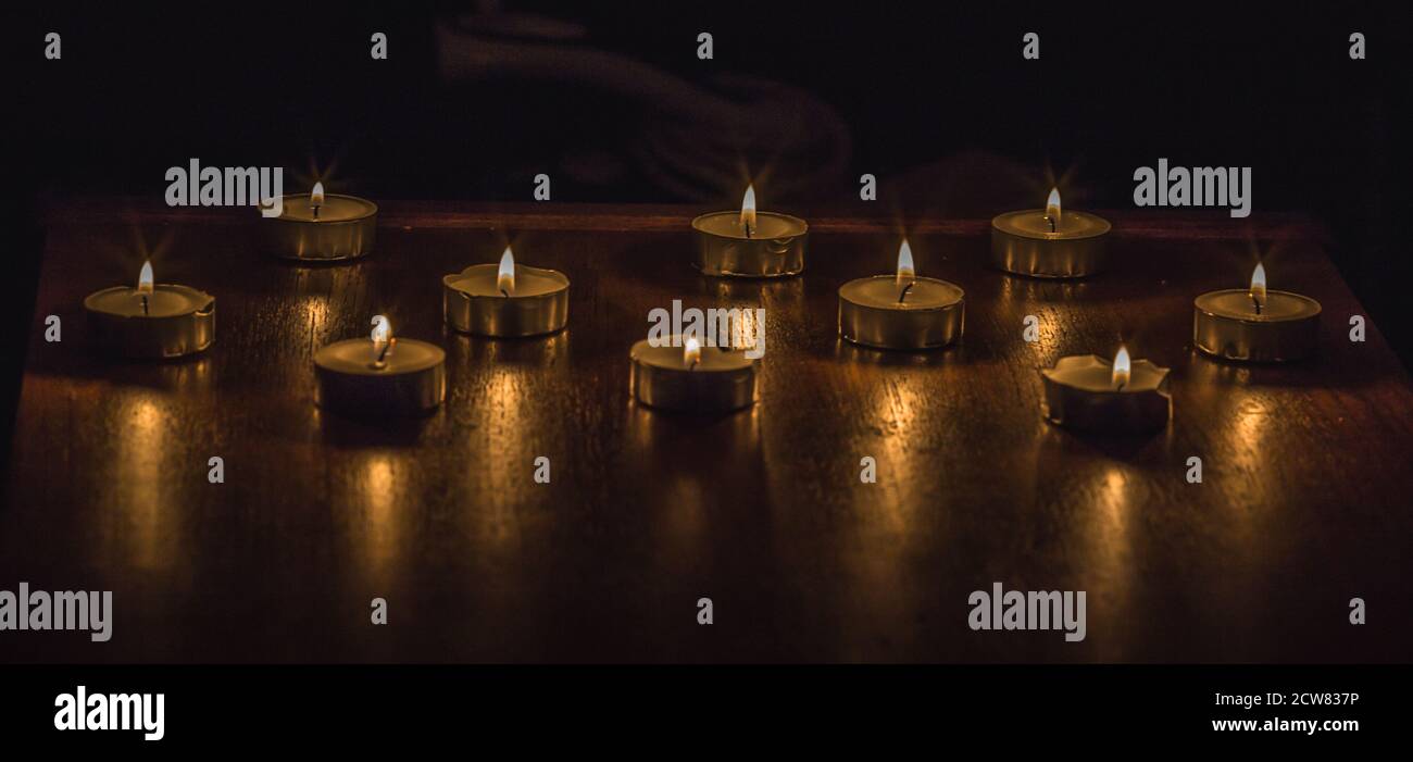 Colpo di closeup di candele brucianti su un tavolo di legno Foto Stock