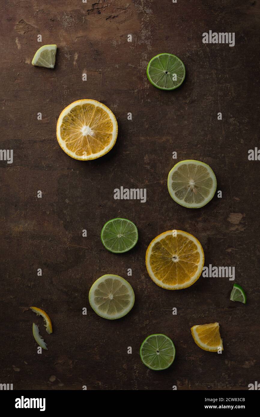 Fette di arancio, limone e lime su tavola di legno Grunge Foto Stock