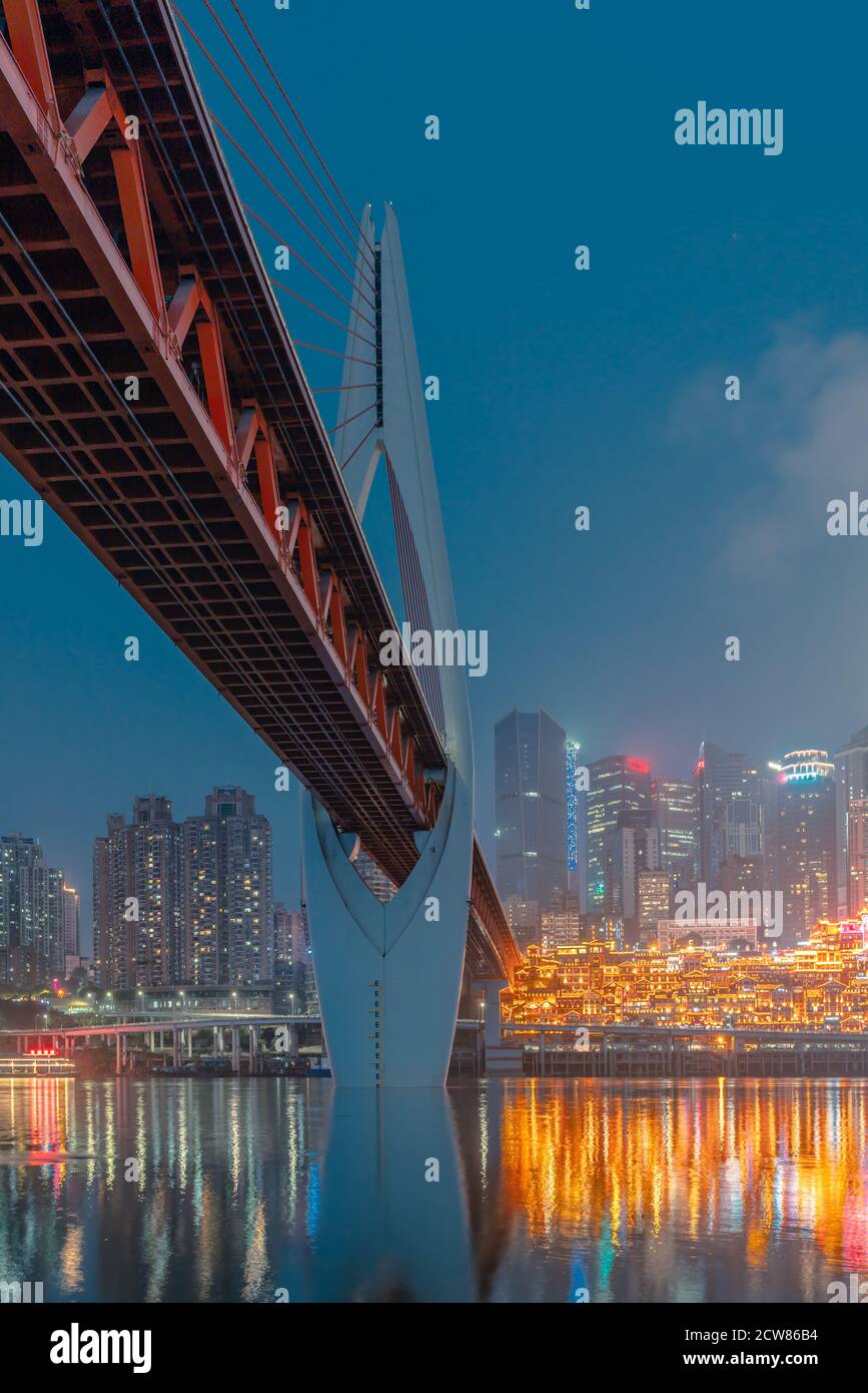 La vista notturna del ponte Qiansimen e dello skyline di Chongqing, Cina. Foto Stock