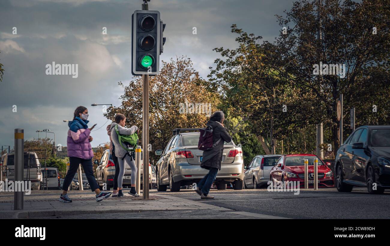 Vita quotidiana. Pericoloso attraversare la strada nel traffico. Pietre di grigio. Irlanda. Foto Stock