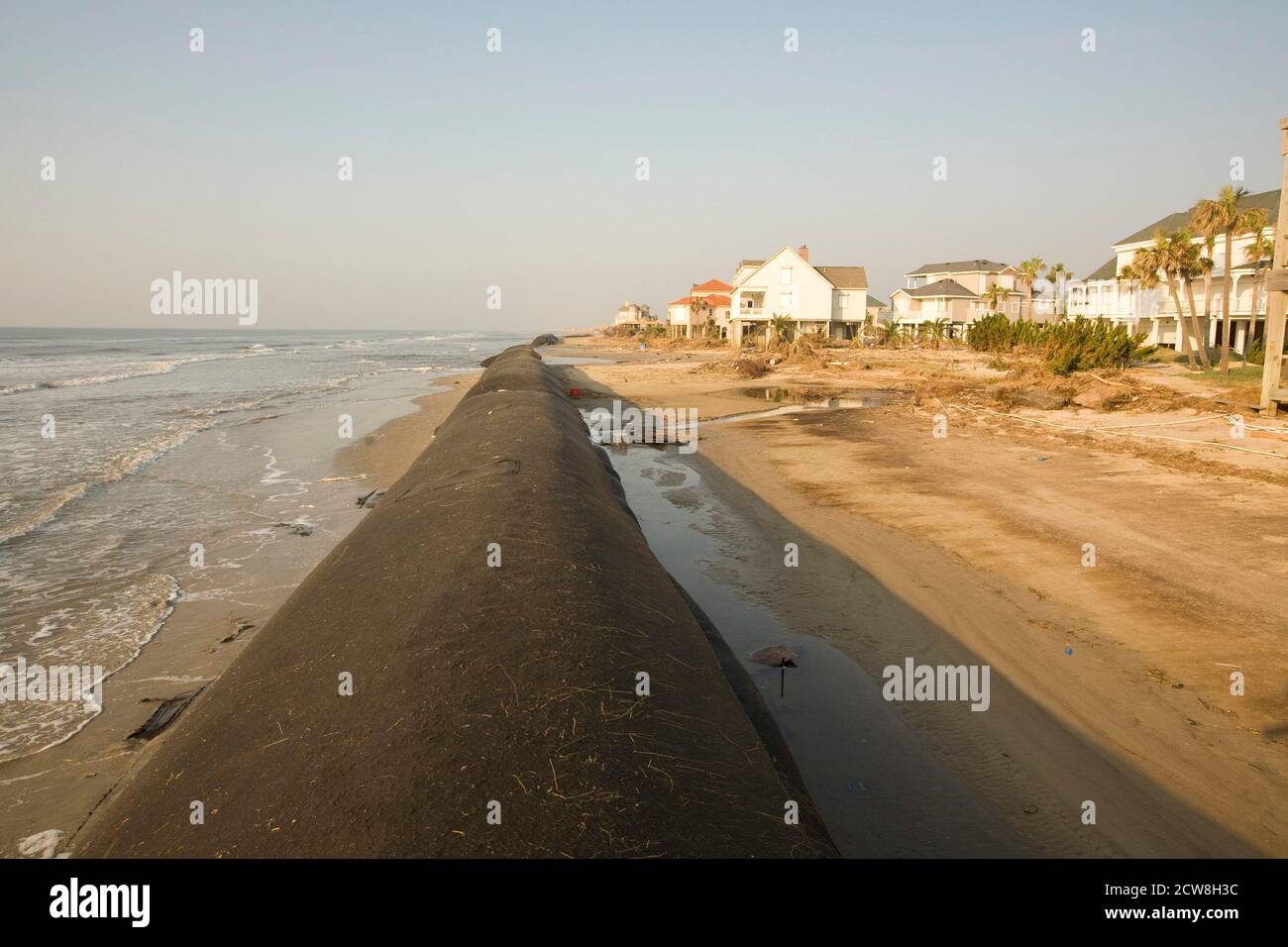 Galveston, Texas 26 settembre 2008: Uragano tempesta danni da uragano Ike litters l'estremità occidentale dell'isola di Galveston quasi due settimane dopo la tempesta di categoria quattro ha colpito l'isola barriera al largo della costa del Texas. Questo è il "Sand Sock", una barriera di sabbia alta 12 metri che doveva proteggere le case del lungomare, ma è stato lavato via dal picco della tempesta dell'uragano. ©Bob Daemmrich Foto Stock