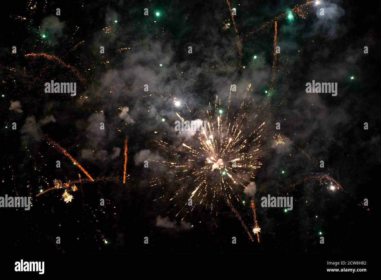 Macchie colorate di fuochi d'artificio in fumo verde su sfondo nero. Sfondo festivo. Foto Stock