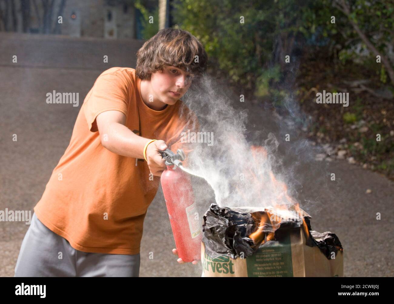 Austin, TX 7 agosto 2008: Un ragazzo anglo di quattordici anni attacca un piccolo incendio domestico con un estintore chimico a secco. Modello rilasciato. ©Bob Daemmrich Foto Stock